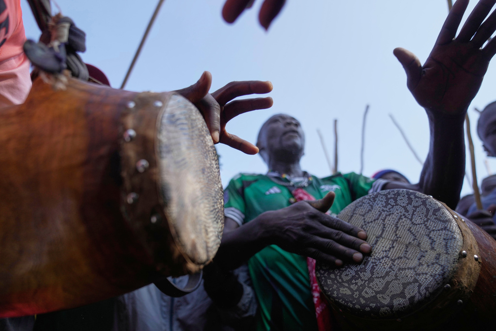 A crowd of spectators dances and sings "Isukuti," a traditional dance accompanied by a set of three drums, after bull Shakahola won bullfighting match, in Kakamega, Kenya, Saturday, Nov. 29, 2025. (AP Photo/Brian Inganga)