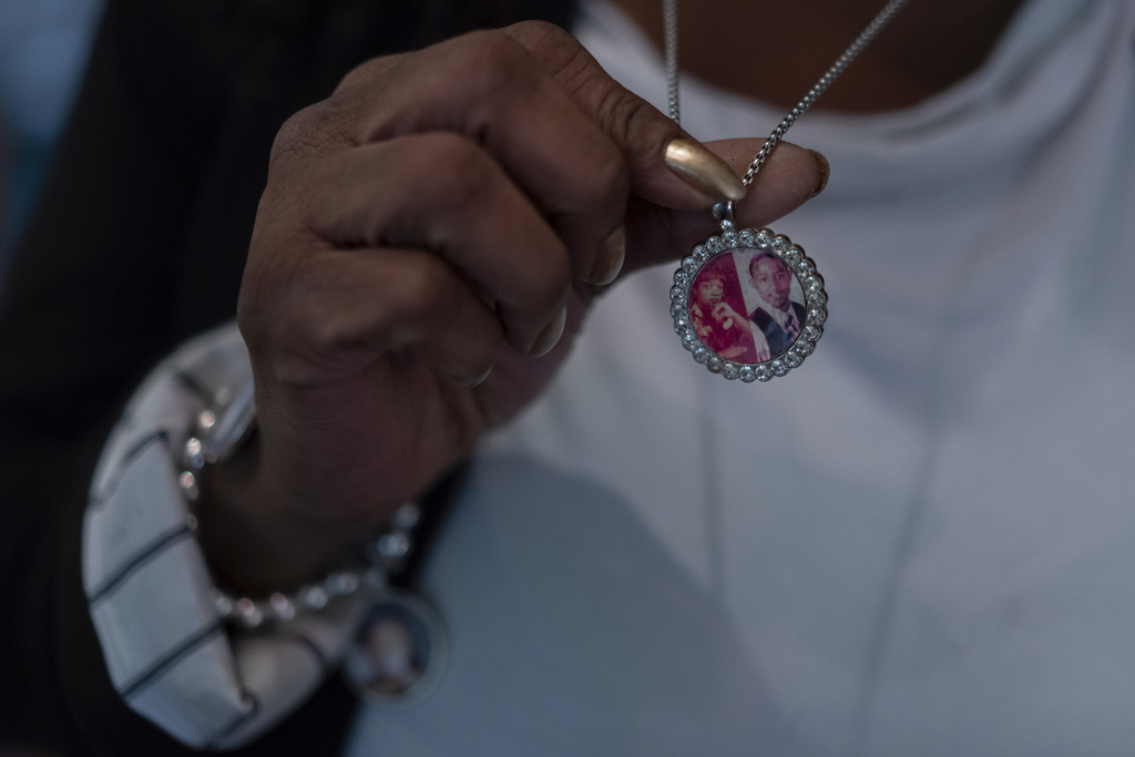 Delphine Cherry holds her necklace with images of two of her children, Tyesa Abney and Tyler Randolph Friday, Sept. 5, 2025, in Hazel Crest, Ill. (AP Photo/Carolyn Kaster)
