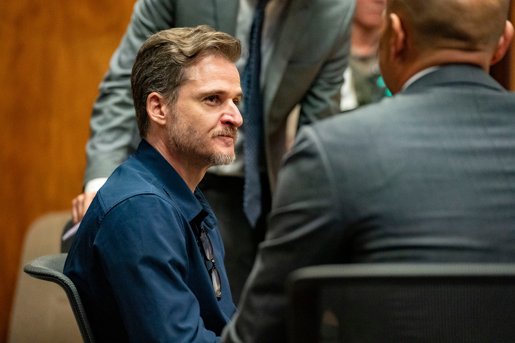 Gerhardt Konig, left, talks to his defense lawyer Thomas Otake after closing arguments in his attempted murder trial in a courtroom, Tuesday, April 7, 2026, in Honolulu. (AP Photo/Mengshin Lin, Pool)