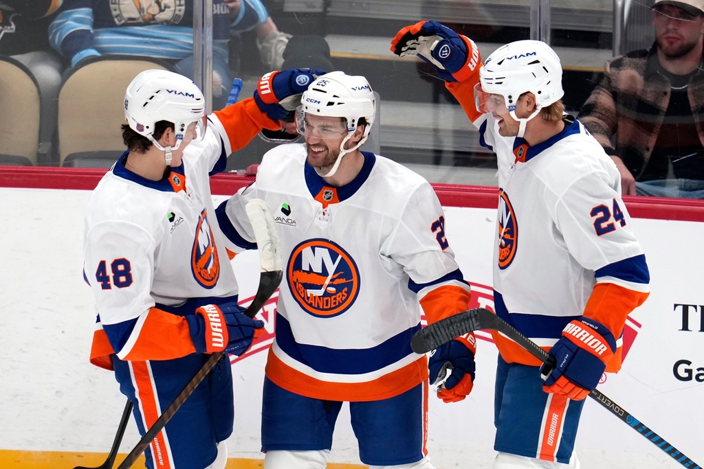 New York Islanders' Jonathan Drouin (29) celebrates after his goal with Matthew Schaefer (48) and Scott Mayfield (24) during the first period of an NHL hockey game against the Pittsburgh Penguins in Pittsburgh, Thursday, Oct. 9, 2025. (AP Photo/Gene J. Puskar)