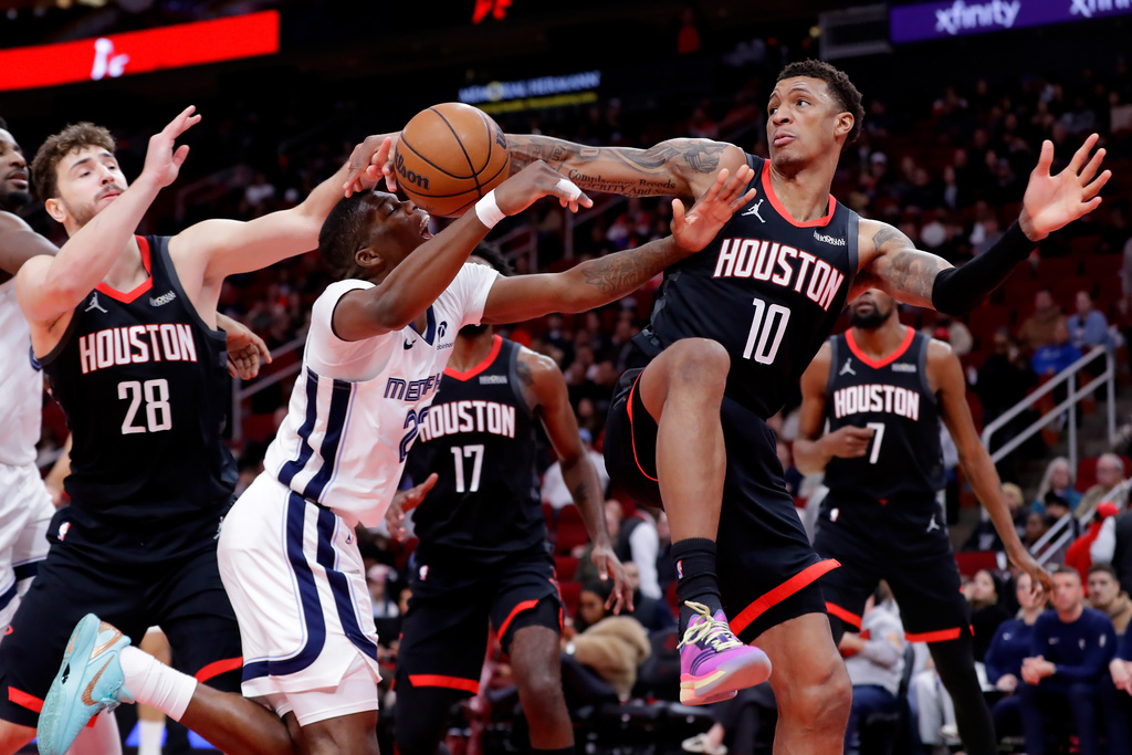 Memphis Grizzlies forward Cedric Coward, center, has his shot attempt blocked by Houston Rockets forward Jabari Smith Jr. (10) as center Alperen Sengun (28) looks on during the first half of an NBA basketball game Monday, Jan. 26, 2026, in Houston. (AP Photo/Michael Wyke)