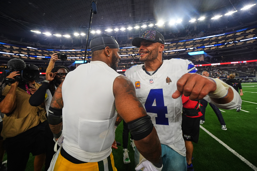 Green Bay Packers defensive end Micah Parsons, left, and Dallas Cowboys quarterback Dak Prescott (4) greet each other after their team's overtime NFL football game which ended in a tie Sunday, Sept. 28, 2025, in Arlington, Texas. (AP Photo/Julio Cortez)