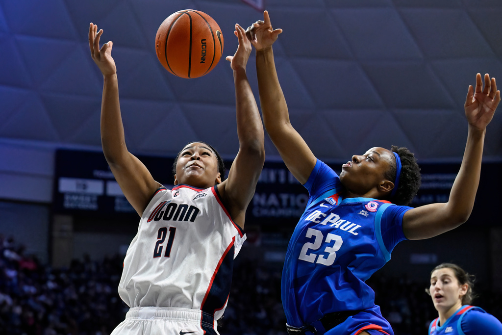 UConn forward Sarah Strong (21) grabs a rebound against DePaul forward Michelle Ojo (23) in the first half of an NCAA college basketball game, Sunday, Dec. 7, 2025, in Storrs, Conn. (AP Photo/Jessica Hill)