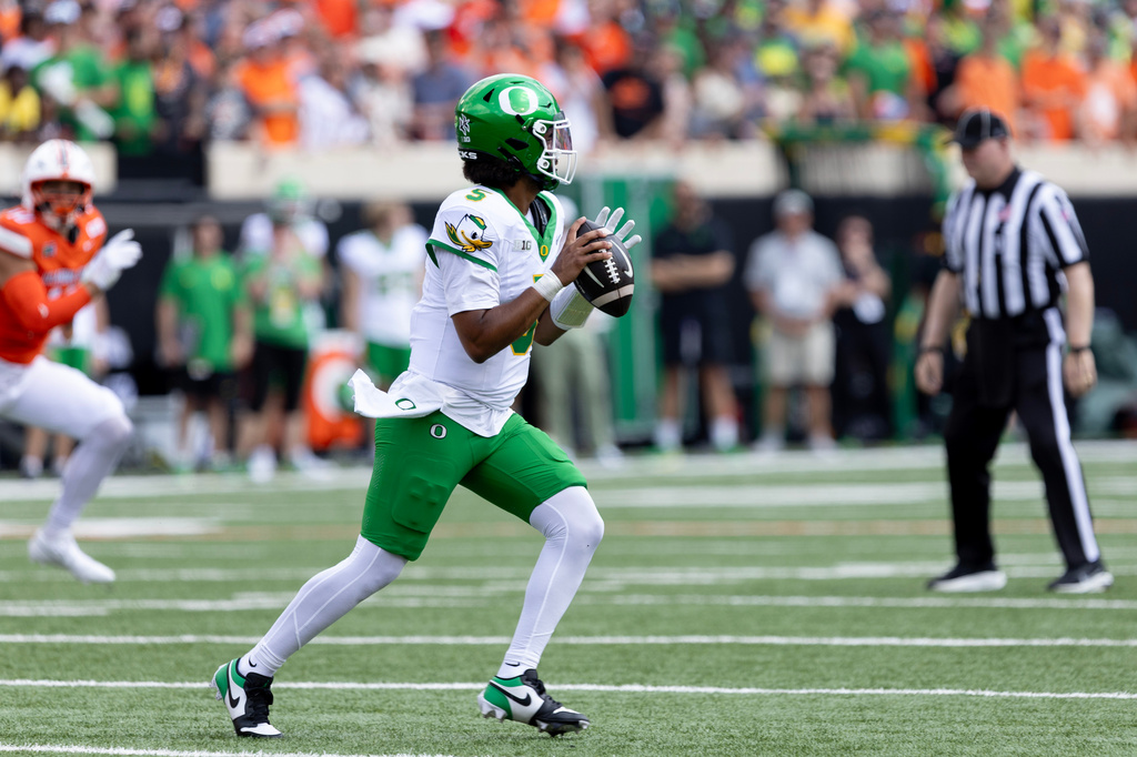 Oregon quarterback Dante Moore (5) rolls out of the pocket in the first half of the NCAA college football game against Oklahoma State in Stillwater, Okla., Saturday, Sept. 12, 2026. (AP Photo/Mitch Alcala)