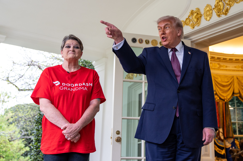 Sharon Simmons with DoorDash, listens as President Donald Trump speaks with reporters outside the Oval Office of the White House, Monday, April 13, 2026, in Washington. (AP Photo/Alex Brandon)