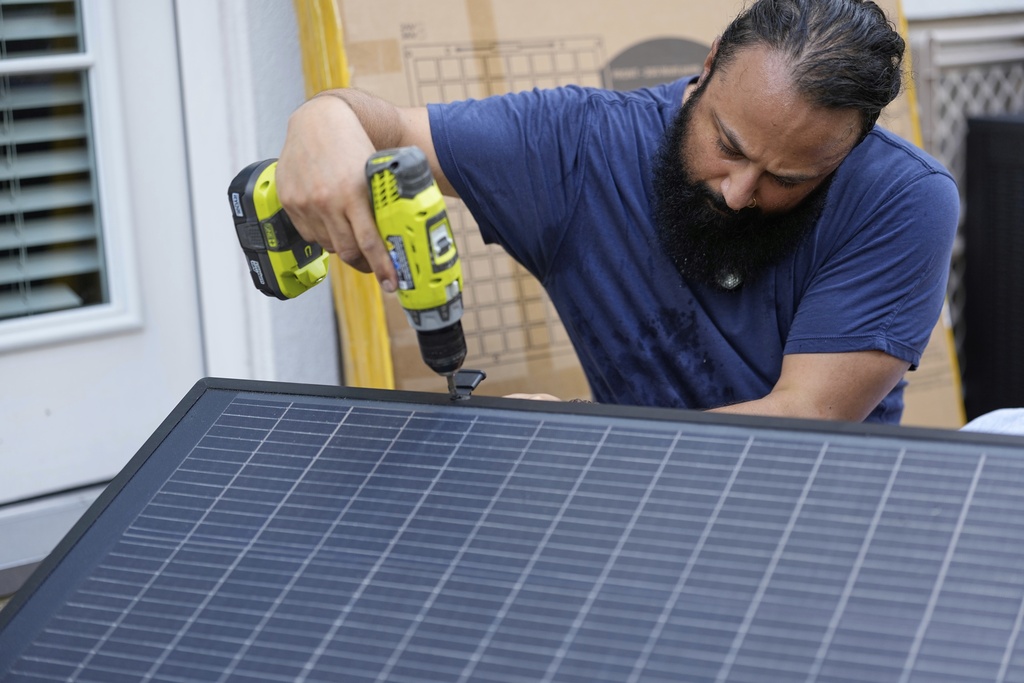 Bhavin Misra assembles a Craftstrom Solar plug-in kit at his home Tuesday, Aug. 5, 2025, in Houston. (AP Photo/David J. Phillip)