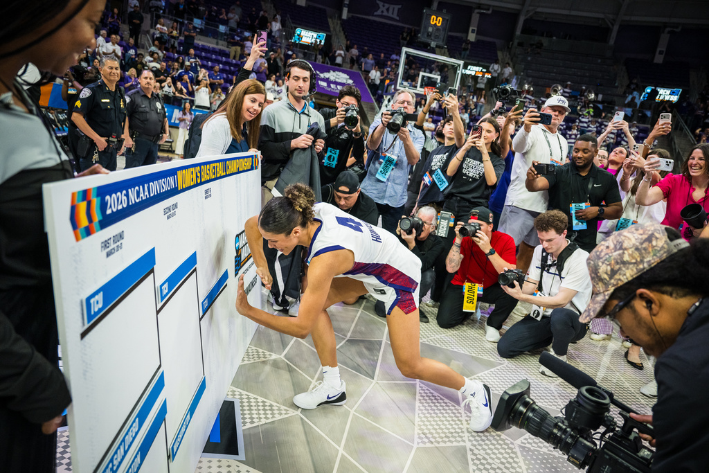 TCU guard Donovyn Hunter (4) places the team placard on the bracket board after the second round of the NCAA college basketball tournament Sunday, March 22, 2026, Fort Worth, Texas. (AP Photo/Jessica Tobias)