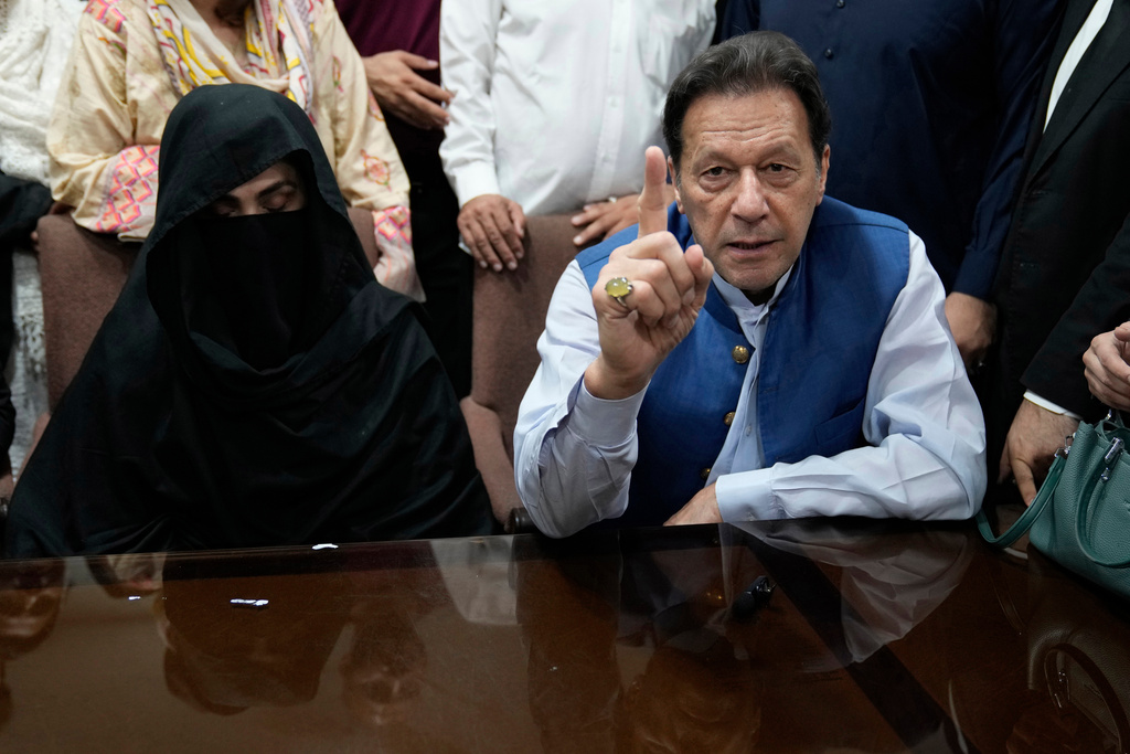 FILE - Pakistan's former Prime Minister Imran Khan, right, and Bushra Bibi, his wife, speak to the media before signing documents to submit surety bond over his bails in different cases, at an office of Lahore High Court in Lahore, Pakistan, on July 17, 2023. (AP Photo/K.M. Chaudary, File)