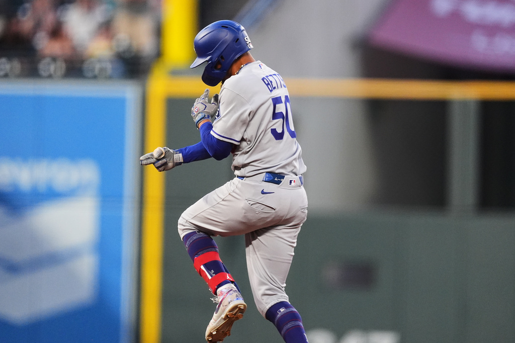 Los Angeles Dodgers' Mookie Betts jumps as he circles the bases after hitting a solo home run off Colorado Rockies starting pitcher Kyle Freeland in the fourth inning of a baseball game Wednesday, Aug. 19, 2026, in Denver. (AP Photo/David Zalubowski)