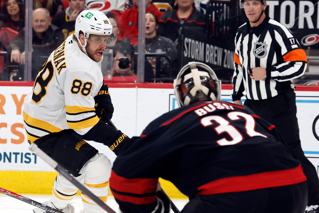 Boston Bruins' David Pastrnak (88) drives the puck toward Carolina Hurricanes goaltender Brandon Bussi (32) during the first period of an NHL hockey game in Raleigh, N.C., Tuesday, April 7, 2026. (AP Photo/Karl DeBlaker)