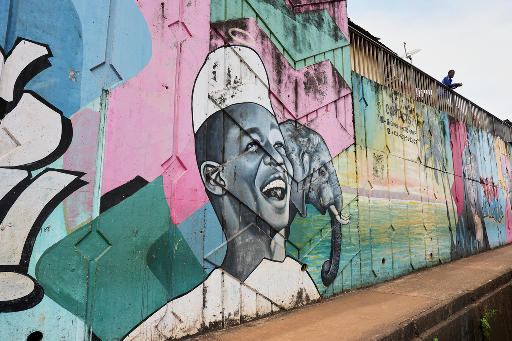 A mural depicting a smiling man with an elephant painted by Omar Diaw on a street wall in Conakry, Guinea, Saturday, Sep. 20, 2025. (AP Photo/Misper Apawu)