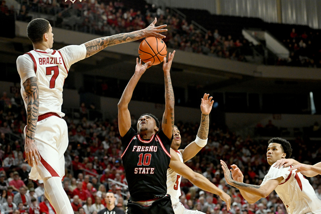 Arkansas forward Trevon Brazile (7) blocks the shot of Fresno State guard Zaon Collins (10) during the first half of an NCAA college basketball game, Saturday, Dec. 6, 2025, in North Little Rock, Ark. (AP Photo/Michael Woods)