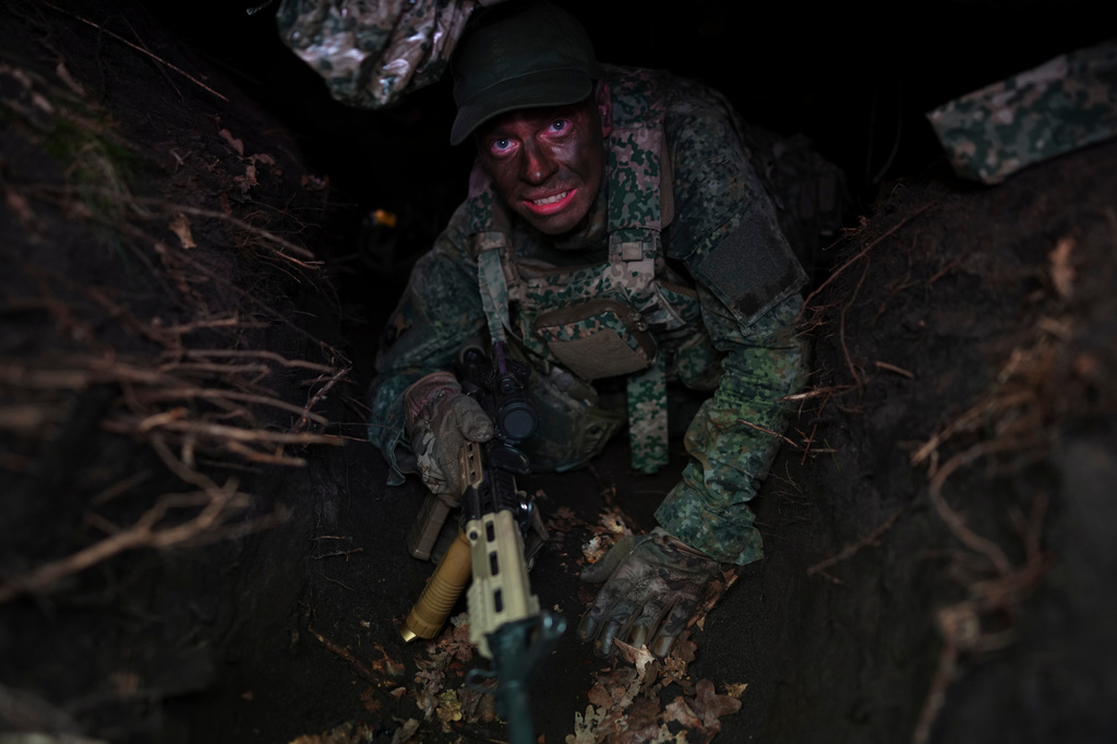 A member of the 10th Infantry Battalion Guard Security Corps National Reserve crawls out of a foxhole during a weekend exercise as the Netherlands beefs up its military with new recruits and volunteer reservists in Havelte, Netherlands, Saturday, April 25, 2026. (AP Photo/Peter Dejong)