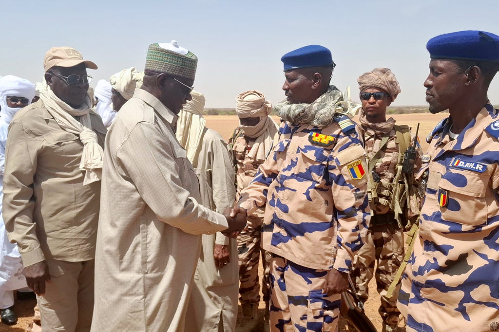 In this photo release by the Chadian Press Agency, Limane Mahamat, deputy prime minister, center left, is greeted upon his arrival at Igote village following a clash between two families over a water point, in the Wadi Fira, Chad, Sunday, April 26, 2026. (Chadian Press Agency via AP)