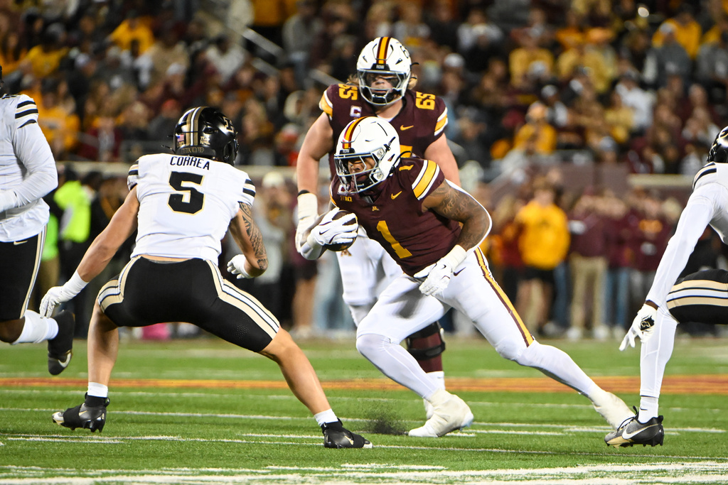Minnesota running back Darius Taylor (1) runs past Purdue linebacker Charles Correa (5) during the first half of an NCAA college football game on Saturday, Oct. 11, 2025, in Minneapolis. (AP Photo/Craig Lassig)