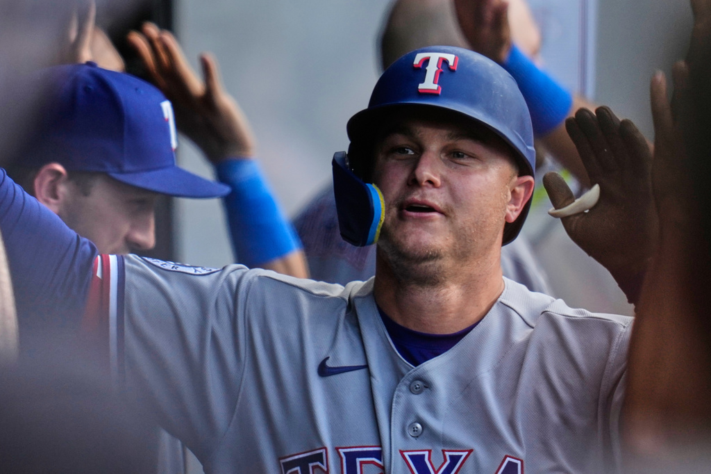 Texas Rangers' Joc Pederson is congratulated in the dugout after hitting a home run in the third inning of a baseball game against the Cleveland Guardians in Cleveland, Tuesday, June 30, 2026. (AP Photo/Sue Ogrocki)