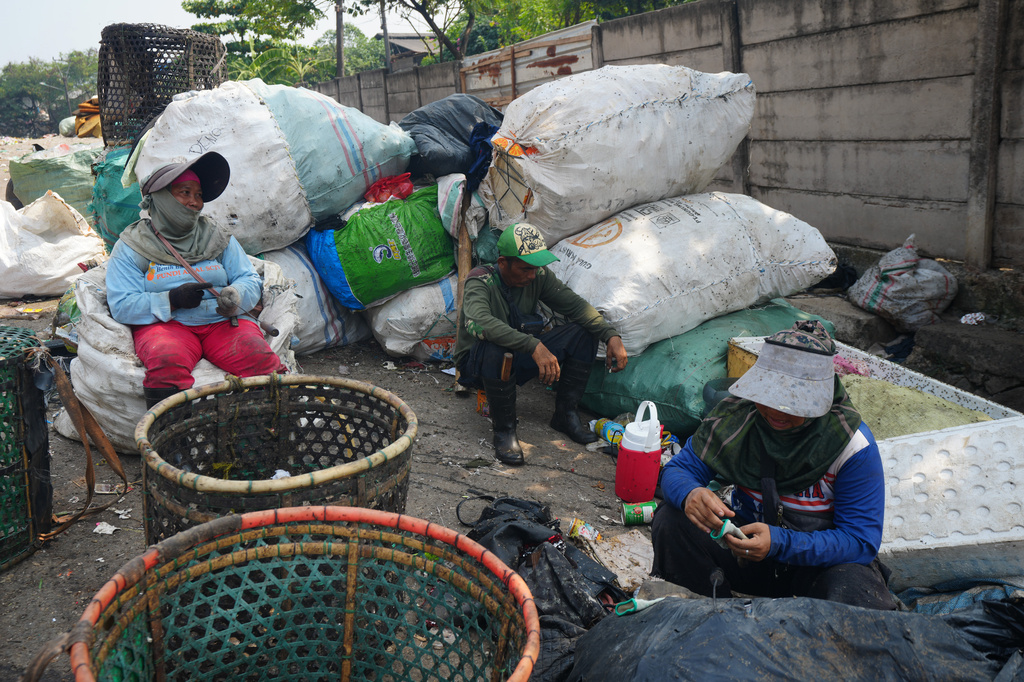 Waste pickers take a rest near at the Bantargebang landfill on the outskirts of Jakarta, Indonesia, Monday, July 6, 2026. (AP Photo/Tatan Syuflana)