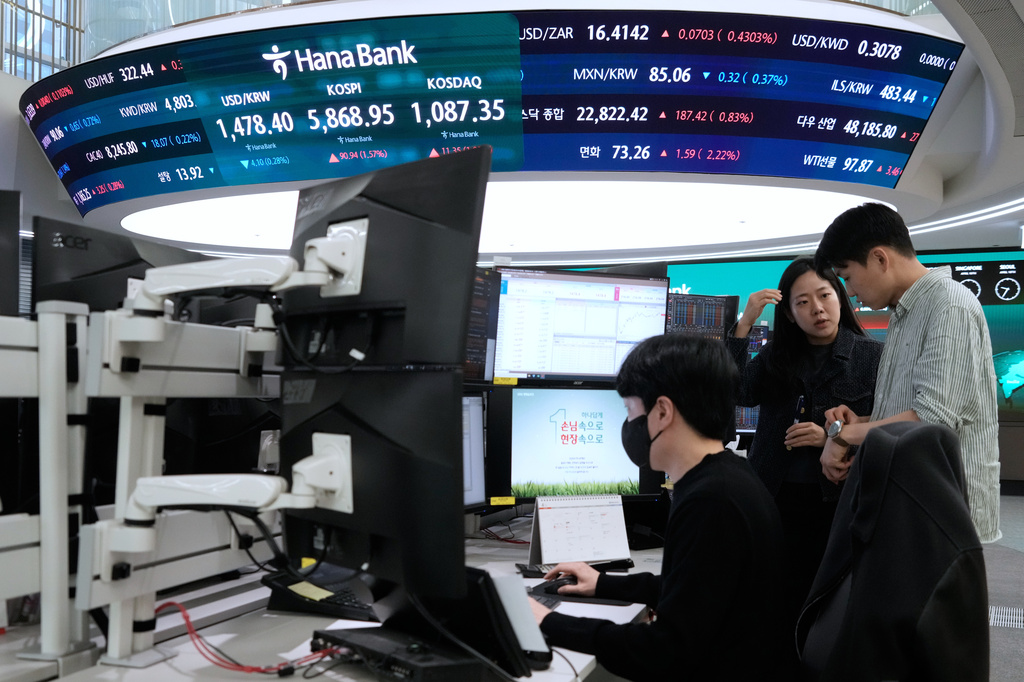 Currency traders work near a screen showing the Korea Composite Stock Price Index (KOSPI), top center, and the foreign exchange rate between U.S. dollar and South Korean won, top center left, at the foreign exchange dealing room of the Hana Bank headquarters, in Seoul, South Korea, Friday, April 10, 2026. (AP Photo/Ahn Young-joon)