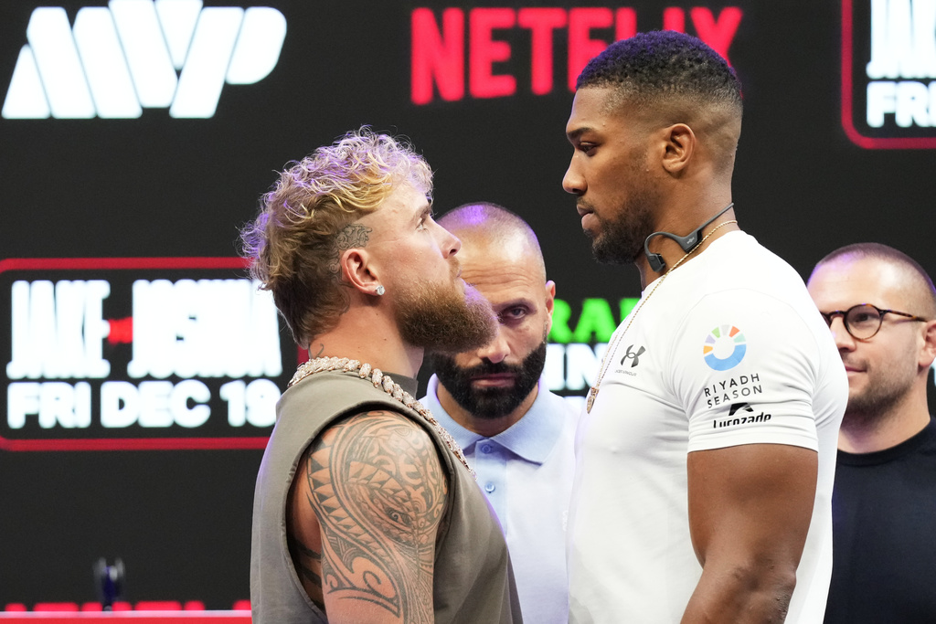 Jake Paul, left, and Anthony Joshua, right, face off during a news conference promoting their upcoming heavyweight boxing match, Friday, Nov. 21, 2025, in Miami. (AP Photo/Lynne Sladky)
