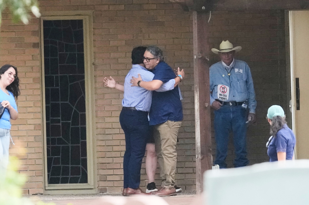 Ronaldo Salgado, center left, son of Lorenzo Salgado Araujo, who was shot and killed by an ICE officer last week, is hugged outside a public visitation for his father Thursday, July 16, 2026, in Houston. (AP Photo/David J. Phillip)