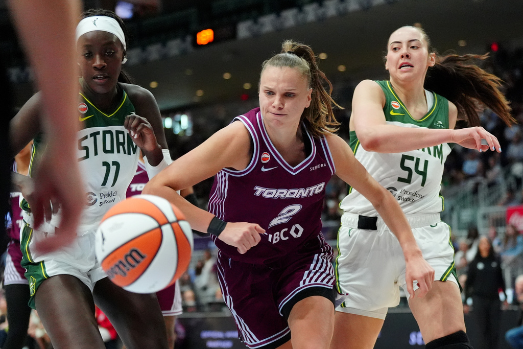 Toronto Tempo forward Laura Juskaite (2) chases down a loose ball as Seattle Storm forward MacKenzie Holmes (54) and teammate Awa Fam (11) look on during a WNBA basketball game in Toronto, Saturday, May 30, 2026. (Frank Gunn/The Canadian Press via AP)