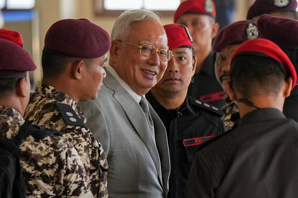 Former Malaysian Prime Minister Najib Razak, center, is escorted by prison officers on his arrival at the Kuala Lumpur High Court Complex, in Kuala Lumpur, Malaysia, Monday, Dec. 22, 2025. (AP Photo/Azneal Ishak)