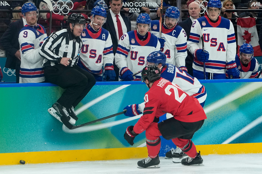 United States' Matt Boldy (12) and Canada's Thomas Harley (20) vie for the puck during the second period of a men's ice hockey gold medal game between Canada and the United States at the 2026 Winter Olympics, in Milan, Italy, Sunday, Feb. 22, 2026. (AP Photo/Petr David Josek)