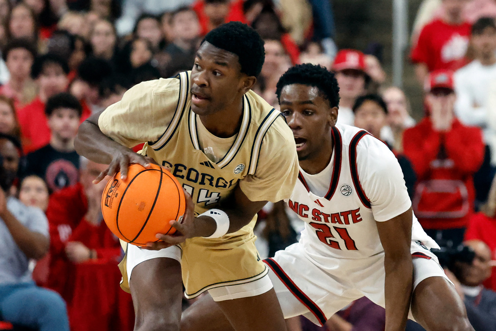 Georgia Tech's Kowacie Reeves Jr. (14) battles for the ball with North Carolina State's Terrance Arceneaux (21) during the first half of an NCAA college basketball game in Raleigh, N.C., Saturday, Jan. 17, 2026. (AP Photo/Karl DeBlaker)