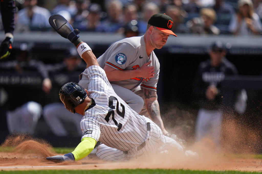 New York Yankees' José Caballero, left, slides past Baltimore Orioles pitcher Kyle Bradish, right, to score on a passed ball during the third inning of a baseball game Saturday, May 2, 2026, in New York. (AP Photo/Frank Franklin II)