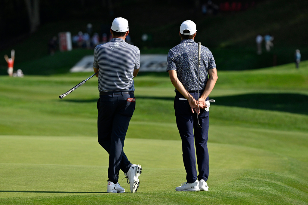 Keegan Bradley, left, and Jordan Spieth, right, wait to play at the 15th hole during the first round of the Travelers Championship golf tournament at TPC River Highlands, Thursday, June 25, 2026, in Cromwell, Conn. (AP Photo/Jessica Hill)