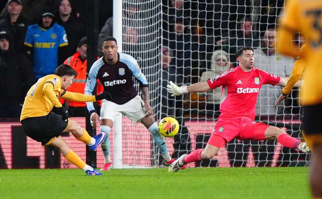 Wolverhampton Wanderers' Rodrigo Gomes, left, scores their second goal during their English Premier League soccer match against Aston Villa in Wolverhampton, England, Friday, Feb. 27, 2026. (Bradley Collyer/PA via AP)