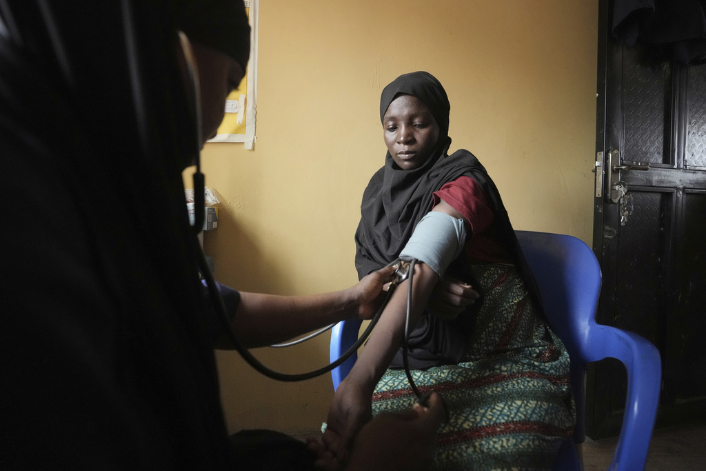 A midwife checks a Falmata Muhammed's blood pressure at a facility run by aid agency International Rescue Committee, in Magumeri, in northeast Nigeria's Borno state, Tuesday, July 22, 2025. (AP Photo/Sunday Alamba)