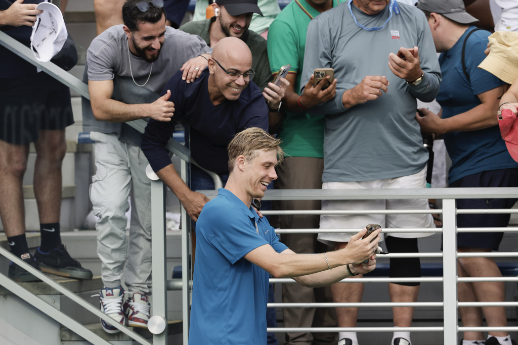 Denis Shapovalov, of Canada, poses for a photo with fans after defeating Valentin Royer, of France, during the second round of the U.S. Open tennis championships, Thursday, Aug. 28, 2025, in New York. (AP Photo/Adam Hunger)