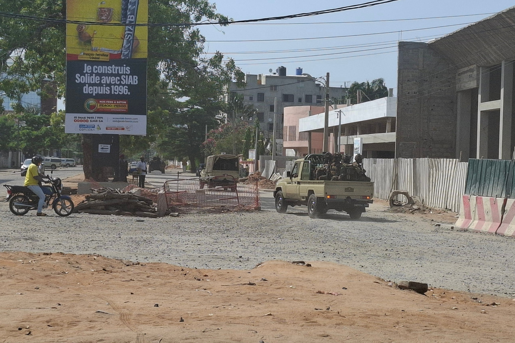 Soldiers ride in a military vehicle along a street amid an attempted coup in Cotonou Benin, Sunday Dec. 6, 2025. (AP Photo)