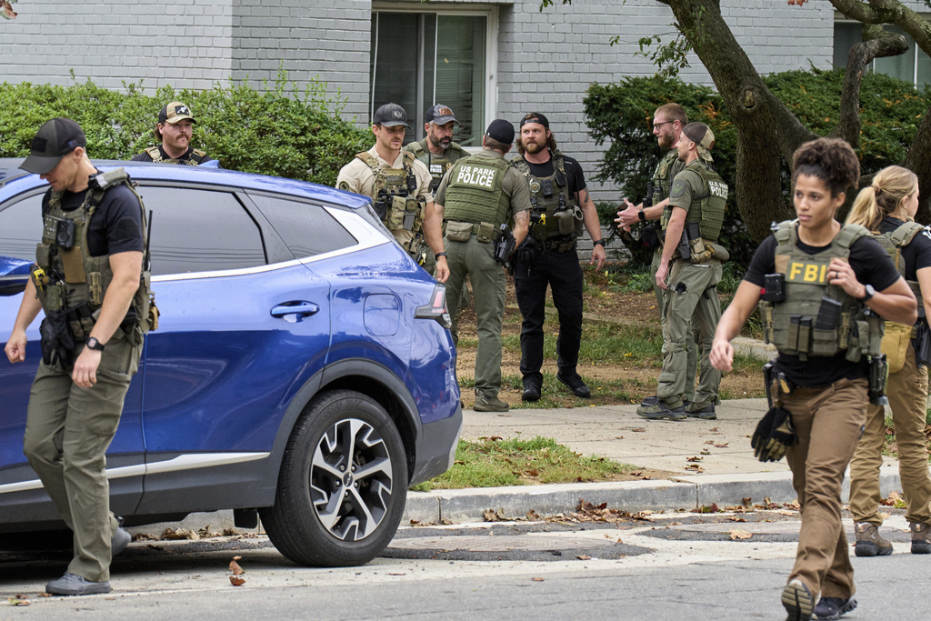 Officers from several federal agencies including FBI, Federal Marshalls, HSI, and Park Police, leave an apartment complex after arresting a man from within the apartments, Tuesday, Aug. 19, 2025, in the Petworth neighborhood of northwest Washington. (AP Photo/Jacquelyn Martin)