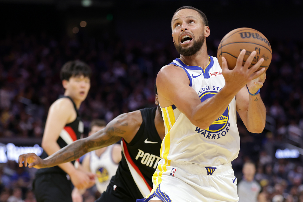 Golden State Warriors' Stephen Curry scores against the Portland Trail Blazers during the first half of an NBA basketball preseason game in San Francisco, Wednesday, Oct. 8, 2025. (Scott Strazzante/San Francisco Chronicle via AP)