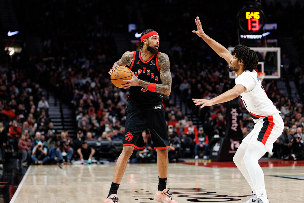 Toronto Raptors forward Brandon Ingram, left, looks to pass the ball against Portland Trail Blazers guard Shaedon Sharpe, right, during the second half of an NBA basketball game Friday, Jan. 23, 2026, in Portland, Ore. (AP Photo/Howard Lao)