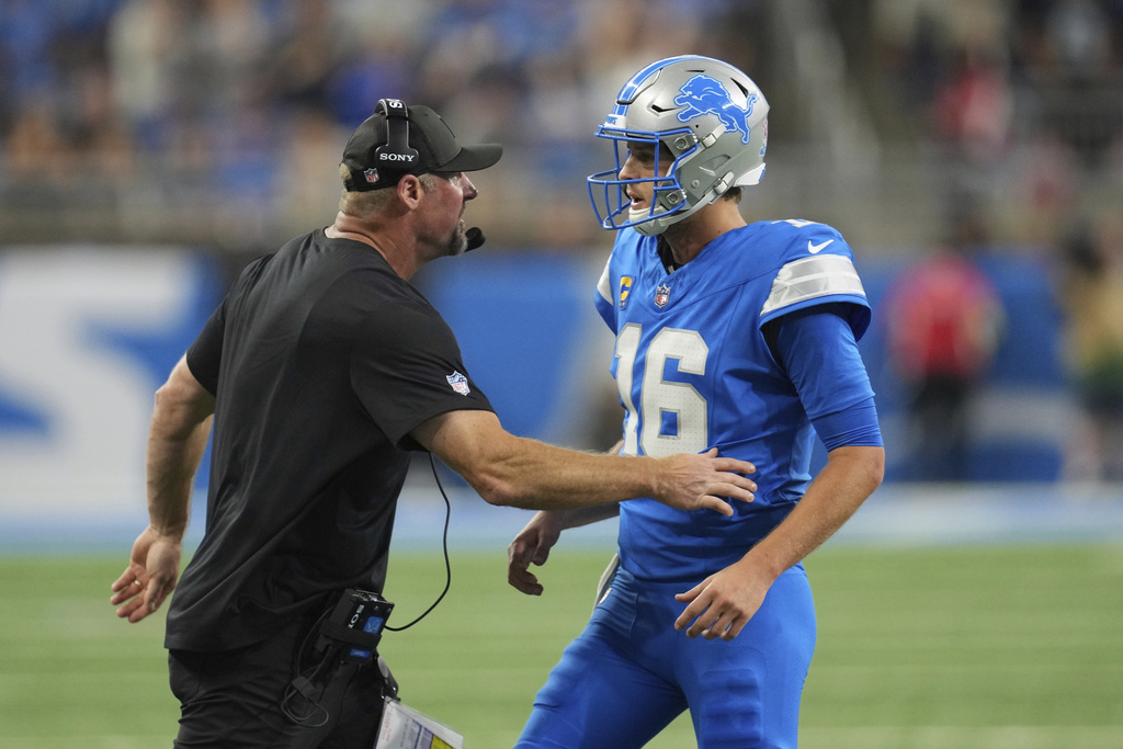 Detroit Lions quarterback Jared Goff (16) talks with head coach Dan Campbell during the first half of an NFL football game against the Chicago Bears in Detroit, Sunday, Sept. 14, 2025. (AP Photo/Paul Sancya)