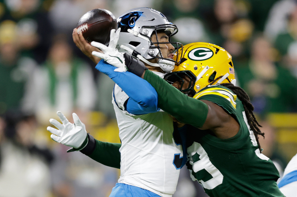 Carolina Panthers quarterback Bryce Young, left, is hit by Green Bay Packers linebacker Ty'ron Hopper, right as he throws a pass during the first half of an NFL football game in Green Bay, Wis., Thursday, Oct. 29, 2026. (AP Photo/Matt Ludtke)