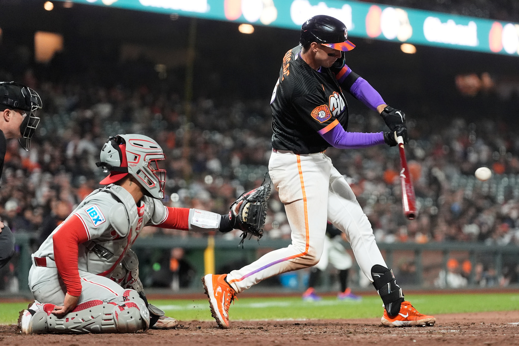 San Francisco Giants' Daniel Susac, right, hits a two-run triple next to Philadelphia Phillies catcher Rafael Marchán, left, during the eighth inning of a baseball game in San Francisco, Tuesday, April 7, 2026. (AP Photo/Jeff Chiu)