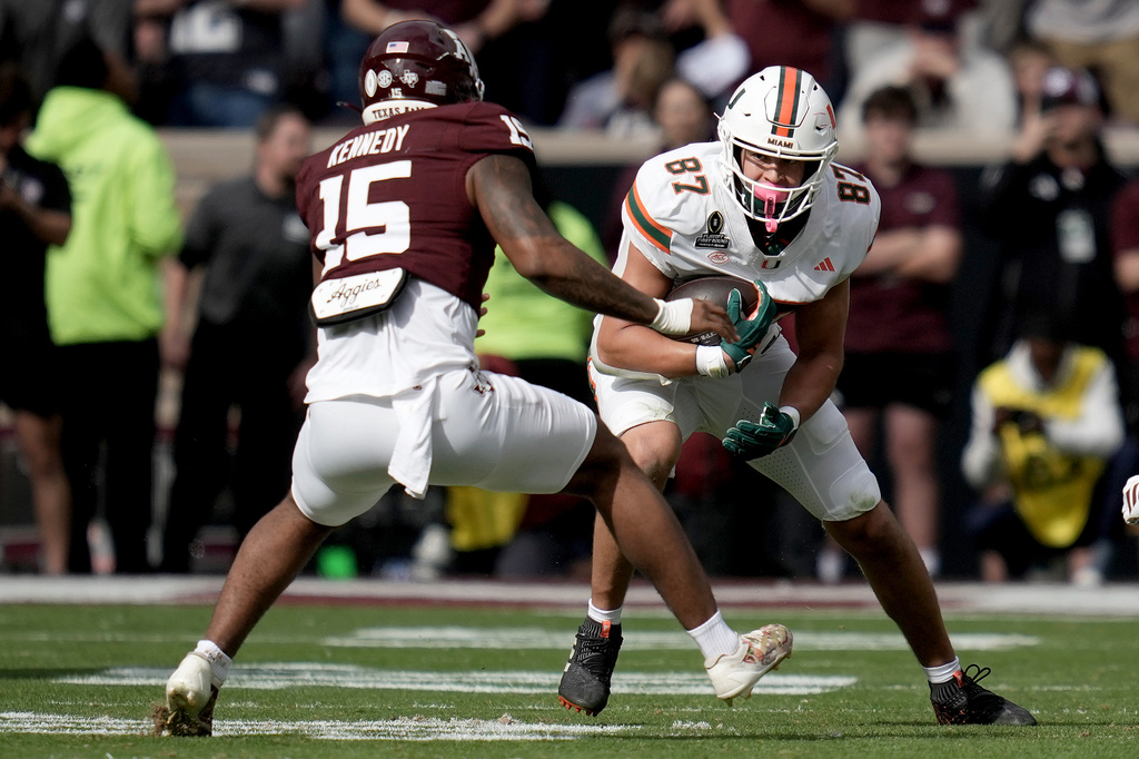 FILE - Miami tight end Alex Bauman (87) looks for yards after a catch against Texas A&M defensive end Rylan Kennedy (15) during the first quarter in the first round of the College Football Playoff Dec. 20, 2025, in College Station, Texas. (AP Photo/Sam Craft, File)