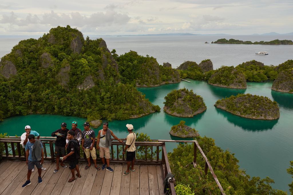 Tourists stand at a viewpoint overlooking the Waigeo Barat islands in Raja Ampat, Indonesia, Thursday, March 5, 2026. (AP Photo/Claudia Rosel)