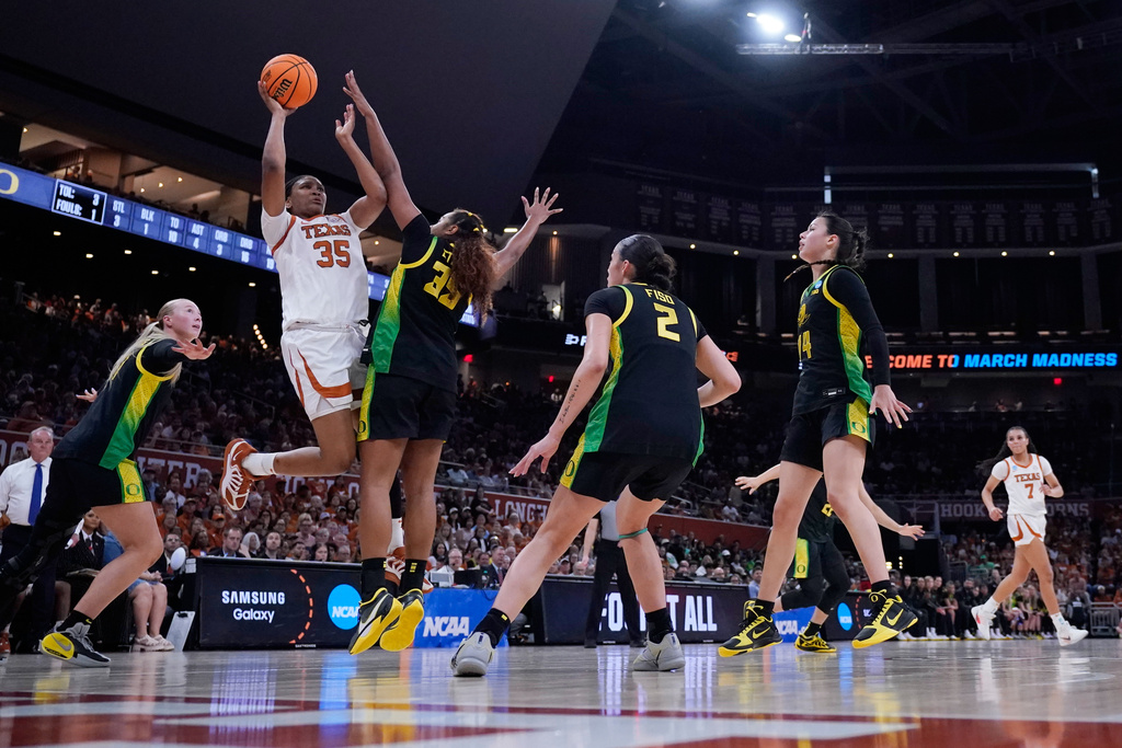 Texas forward Madison Booker (35) drives to the basket against Oregon forward Ehis Etute (35) during the second half in the second round of the NCAA college basketball tournament, Sunday, March 22, 2026, in Austin, Texas. (AP Photo/Eric Gay)