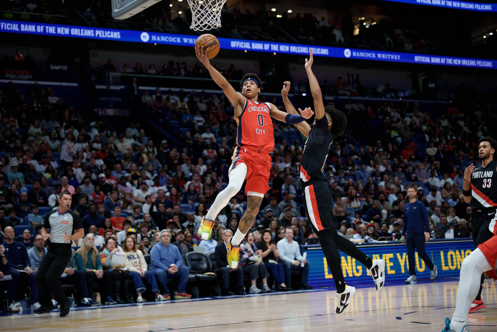 New Orleans Pelicans guard Jeremiah Fears (0) goes up to shoot against Portland Trail Blazers guard Shaedon Sharpe, center right, during the first half of an NBA basketball game in New Orleans, Friday, Jan. 2, 2026. (AP Photo/Matthew Hinton)