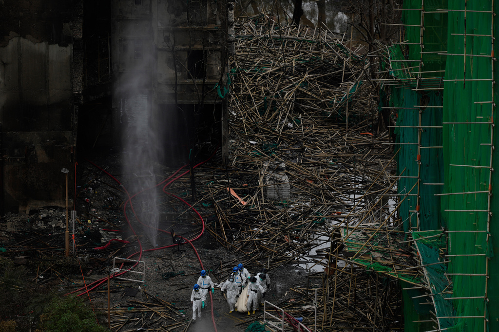 Emergency crew remove what appears to be a body bag from the site of a deadly Wednesday fire at Wang Fuk Court, a residential estate in the Tai Po district of Hong Kong's New Territories on Sunday, Nov. 30, 2025. (AP Photo/Ng Han Guan)