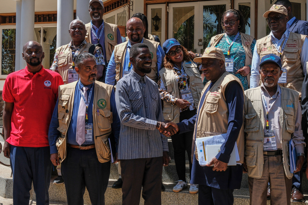 Uganda opposition presidential candidate Robert Kyagulanyi Ssentamu, known as Bobi Wine, center left, greets election observers, including former Nigerian President Goodluck Jonathan, at his home in Magere village on the outskirts of Kampala, Uganda, Wednesday, Jan. 14, 2026. (AP Photo/Hajarah Nalwadda)
