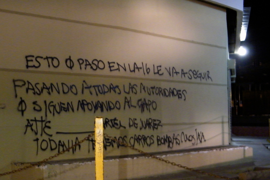 FILE - A wall at a shopping center in Ciudad Juarez, Mexico, in July 2010, is covered by graffiti that reads in Spanish "What happened on the 16 (street) is going to keep happening to all the authorities that continue to support the Chapo (Guzman), sincerely, the Juarez Cartel. We still have car bombs (expletive) ha ha." (AP Photo, File)
