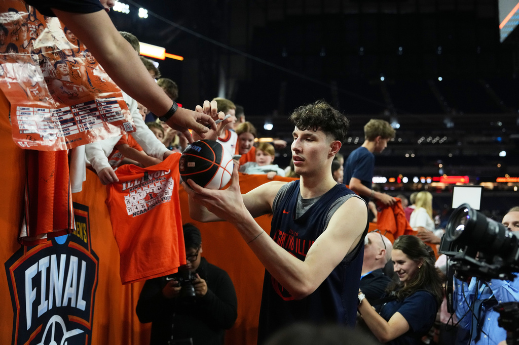 Illinois' Zvonimir Ivisic signs autographs during practice ahead of a national semifinal NCAA college basketball tournament game against UConn at the Final Four, Friday, April 3, 2026, in Indianapolis. (AP Photo/Michael Conroy)