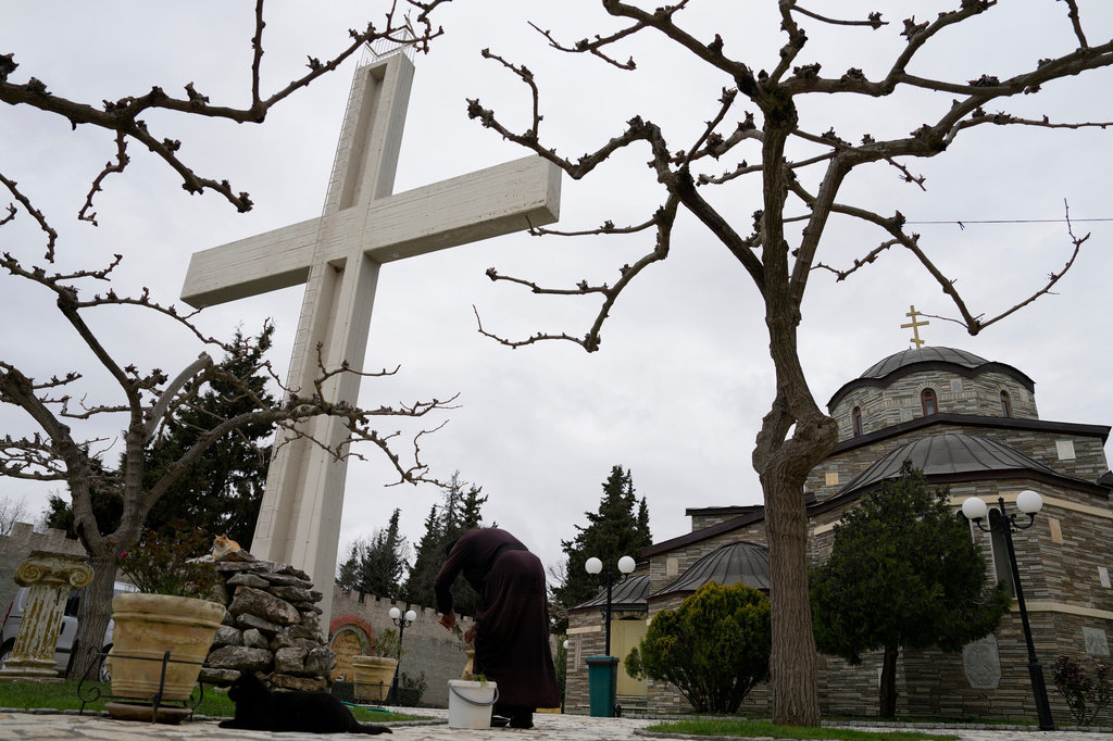 A monk tends to plants at the Monastery of St. Augustine and Seraphim of Sarov in the village of Trikorfo, about 236 kilometers (147 miles) northwest of Athens, Friday, March 20, 2026. (AP Photo/Thanassis Stavrakis)