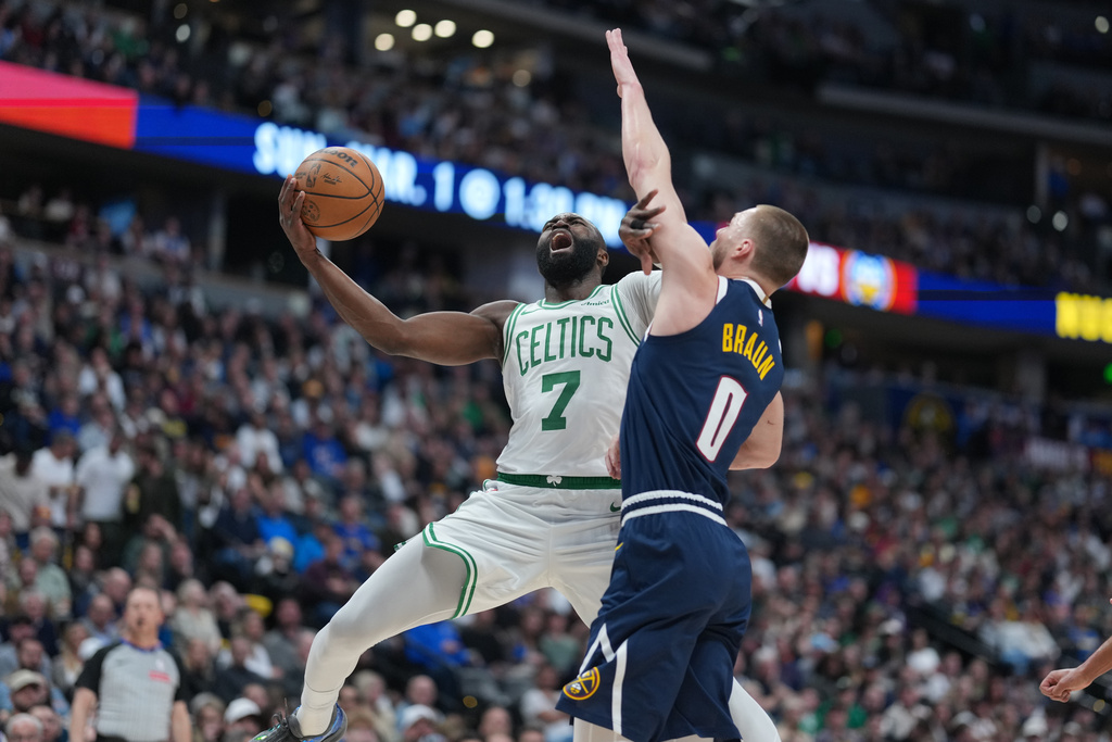 Boston Celtics guard Jaylen Brown, left, drives to the basket as Denver Nuggets guard Christian Braun defends in the first half of an NBA basketball game Wednesday, Feb. 25, 2026, in Denver. (AP Photo/David Zalubowski)